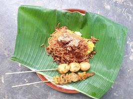 nasi kuning est un plat traditionnel indonésien, servi sur une feuille de bananier et une assiette photo