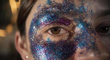 gros plan sur les yeux d'une belle femme composée de particules bleues et violettes formant un masque contre photo