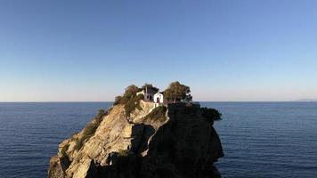 vue aérienne par drone de la pittoresque chapelle de saint jean construite sur la célèbre falaise du film de mama mia, île de skopelos, sporades, grèce. coup de coucher de soleil. photo