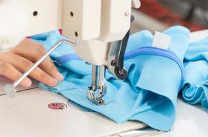 couturière sur la machine coud des vêtements dans une usine de confection photo