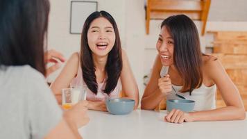 les femmes asiatiques prennent le petit déjeuner à la maison, groupe de jeunes filles amies d'asie se sentant heureuses de s'amuser à parler ensemble tout en prenant le petit déjeuner dans la cuisine le matin. photo