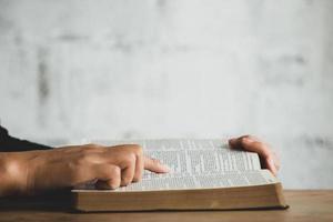 femmes lisant le vieux livre lourd sur fond blanc. photo