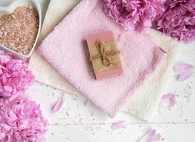 barres de savon artisanal, serviettes douces et fleurs de pivoine photo