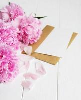 carte d'invitation, enveloppe artisanale et fleurs de pivoine rose photo