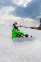 belle jeune femme posant avec un snowboard sur une piste de ski photo