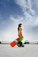 belle jeune femme posant avec un snowboard sur une piste de ski photo