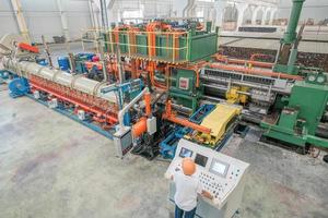 ouvrier derrière le tableau de bord dans l'atelier de production de profilés en aluminium. presse d'extrusion d'aluminium photo