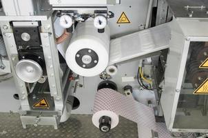 usine et équipement pour la production de serviettes hygiéniques féminines. Coussinets d'hygiène pour femmes sur un gros plan de tapis roulant photo