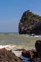 les vagues et les forts vents marins ont balayé les rochers et les hauts-fonds. les vagues et les brises marines s'écrasent contre les rochers et les rivages. photo