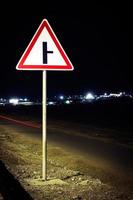 panneau routier la nuit. scène de nuit avec un panneau de signalisation. photo
