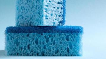 deux éponges bleues utilisées pour laver et effacer la saleté utilisée par les ménagères dans la vie quotidienne. ils sont réalisés en matériau poreux tel que de la mousse. rétention de détergent, ce qui vous permet de le dépenser économiquement photo