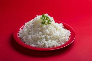 riz basmati blanc ordinaire cuit dans une assiette rouge sur fond rouge photo