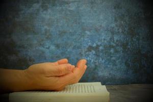 les mains jointes en prière sur une sainte bible dans un concept d'église pour la foi, la spiritualité et la religion, avec une femme priant sur la sainte bible le matin photo