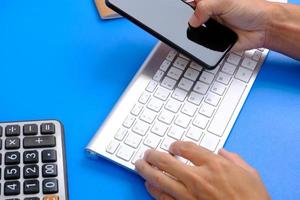 le bloc-notes avec stylo se trouve sur le dessus de la table de bureau avec des outils et des fournitures informatiques. vue de dessus avec espace de copie, mise à plat. publicité financière et bancaire photo