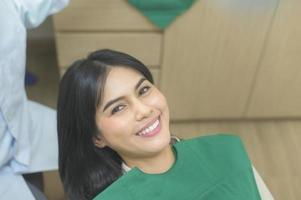 jeune femme ayant des dents examinées par un dentiste dans une clinique dentaire, un contrôle des dents et un concept de dents saines photo
