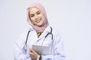 femme médecin musulmane avec hijab sur fond blanc studio. photo