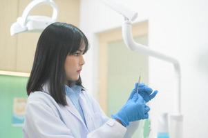 portrait d'une femme dentiste travaillant dans une clinique dentaire, contrôle des dents et concept de dents saines photo