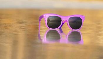 lunettes de soleil mode violet sur le sable belle plage d'été copie espace concept de vacances photo