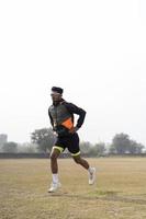 jeune garçon indien faisant de l'exercice et sautant sur le terrain de sport. concept de sport et de mode de vie sain. photo