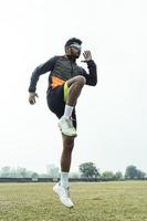 jeune garçon indien faisant de l'exercice et sautant sur le terrain de sport. concept de sport et de mode de vie sain. photo