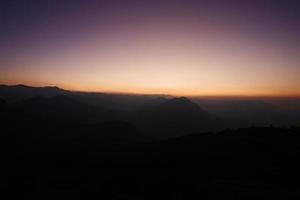 coucher de soleil derrière les collines photo