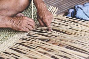 Panier en bambou tissant en bois - vieil homme senior travaillant à la main artisanat panier fait à la main pour le produit de la nature en Asie photo