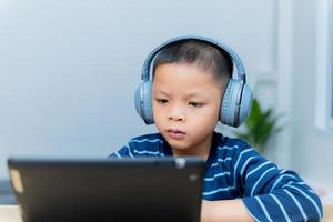 les enfants étudient en ligne via des tablettes à la maison. photo