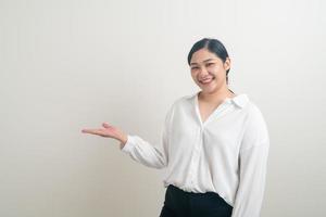 femme asiatique avec la main présente sur le mur blanc photo