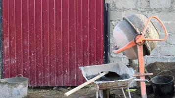 Le malaxeur à béton mobile à gravité avec auto-décharge de couleur orange prépare le mortier de ciment. engin de chantier mobile pour la préparation de mélanges de béton. mélanger des produits en vrac. photo