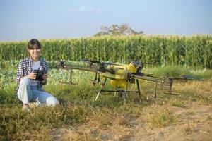 jeune agriculteur intelligent contrôlant la pulvérisation d'engrais et de pesticides par drone sur les terres agricoles, les innovations de haute technologie et l'agriculture intelligente photo