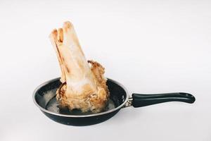 soupe d'os de boeuf ragoût cru dans une casserole isolée sur fond blanc. photo