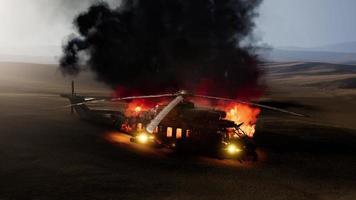 Hélicoptère militaire brûlé dans le désert au coucher du soleil photo