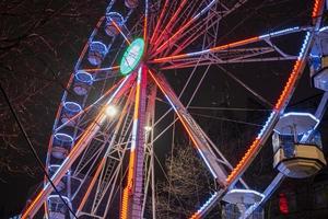 grande roue magnifiquement illuminée la nuit à leeds par la mairie de la ville. photo