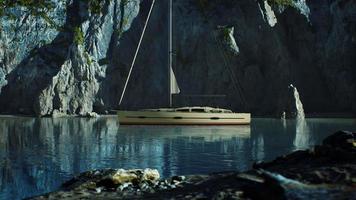 yacht blanc ancré dans une baie aux falaises rocheuses photo