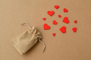 fond d'amour avec des coeurs rouges volant d'un sac d'emballage décoratif. carte de saint valentin créative photo