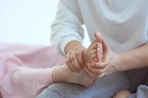 mains faisant un massage thaïlandais des pieds. médecine alternative et concept de massage thaïlandais photo