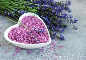 bol en forme de coeur avec du sel de mer et des fleurs de lavande fraîche photo