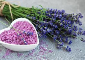 bol en forme de coeur avec du sel de mer et des fleurs de lavande fraîche photo