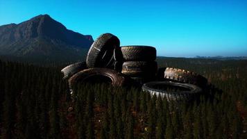 concept de pollution de l'environnement avec de gros vieux pneus dans la forêt de montagne photo