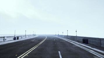 route asphaltée et montagne dans un brouillard profond photo
