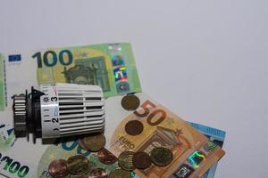 augmentation des prix de l'énergie et de la consommation d'énergie régulateur thermostatique du chauffage avec différents billets et pièces en euros côté gauche photo