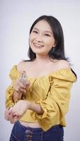 Belle fille asiatique parfum essayant sur sa main isolé sur fond blanc photo
