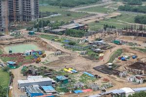 image de drone aérien d'un chantier de construction. l'équipement lourd nivelle le terrain, déplace et aplanit le sol d'argile rouge. photo