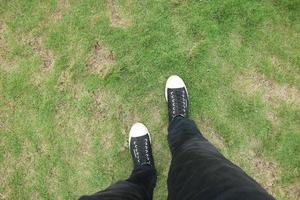 homme portant des chaussures noires debout sur l'herbe photo