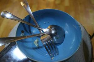 assiette de bol bleu vide avec quelques cuillères photo