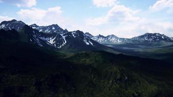 paysage ensoleillé avec vue sur les montagnes enneigées et la prairie photo