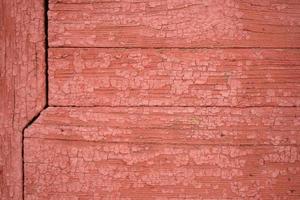 le mur est fait de vieilles planches avec des restes de peinture rouge photo