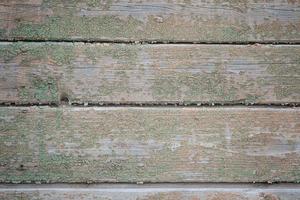 le mur est fait de vieilles planches avec des restes de peinture verte photo