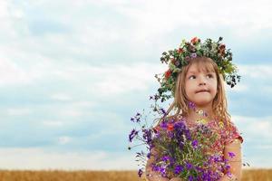 jolie petite fille dans un champ de blé d'été photo