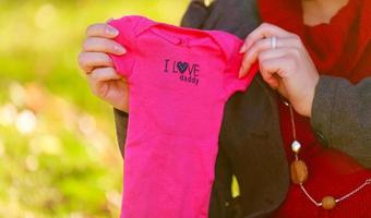 jolie femme enceinte en rouge posant dans un parc verdoyant. jeune femme photo